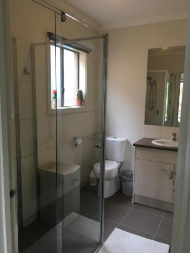 a bathroom with a shower and a toilet and a sink at Apple House in Tarneit