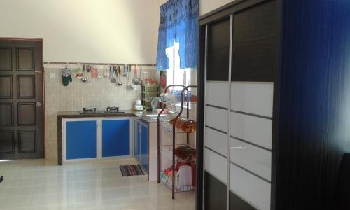uma cozinha com armários azuis e brancos e um lavatório em Homestay Kg Paya D Jitra em Jitra