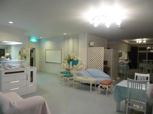 a bedroom with a bed and a table and chairs at Hotel Sha La La in Okinawa City