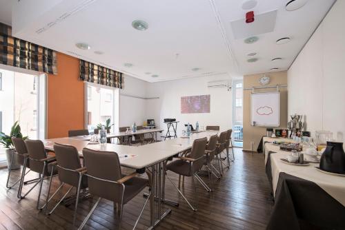 a dining room with tables and chairs and a white ceiling at Hotel Nibelungen Hof in Xanten