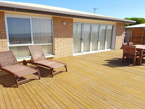 a deck with chairs and a table on a building at White Sands Estate in Falmouth