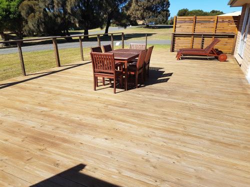 a wooden deck with a table and chairs on it at White Sands Estate in Falmouth