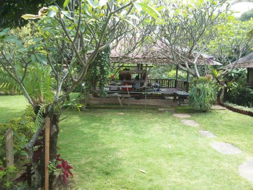 a garden with a picnic table and a bench at ESA di Kubu Homestay in Singaraja
