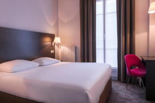 une chambre d'hôtel avec un lit et un fauteuil rouge dans l'établissement Hôtel des Ecrivains, à Paris
