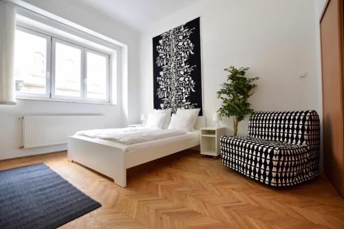 ブダペストにあるBudget Apartment by Hi5 - Akácfa 4の白いベッドルーム(ベッド1台、椅子付)