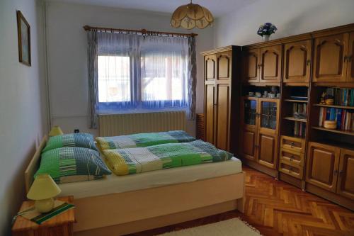 1 dormitorio con cama y ventana en Pingvin Cukrászda Apartman, en Balatonmáriafürdő