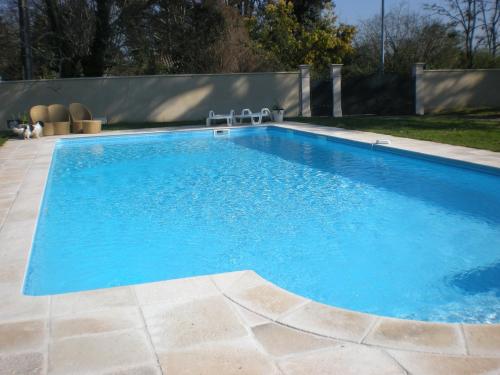 basen z błękitną wodą na dziedzińcu w obiekcie Le Manoir de la Riviere w mieście Saint-Seurin-de-Prats