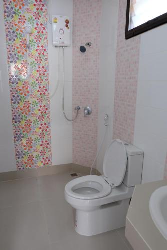 a bathroom with a white toilet and a shower at Bualuang Boutique Resort in Ang Thong
