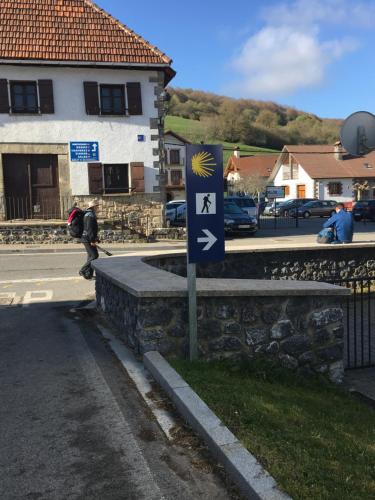 a person riding a skateboard next to a sign on a street at Apartamentos Irati in Espinal-Auzperri