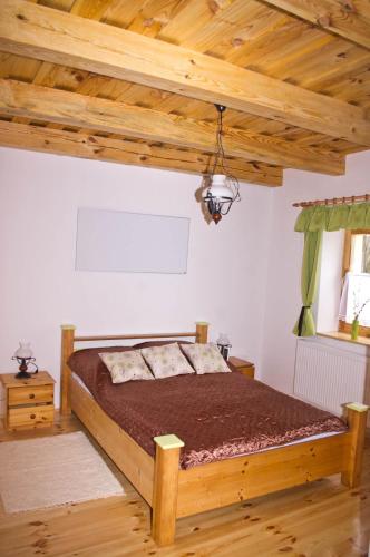 a bedroom with a bed in a room with wooden ceilings at Harmatcsepp-Vendégház in Kercaszomor
