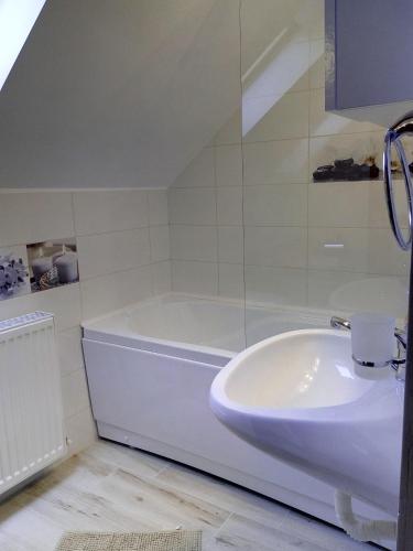 a white bathroom with a tub and a sink at Vila Slănic family boutique hotel by Di'aDOR rentals in Slănic