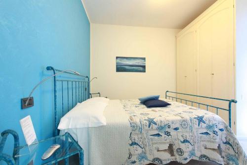 a bedroom with a bed with a blue wall at La Rosa Dei Venti in Monterosso al Mare