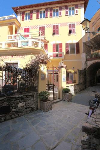 a large yellow building with a gate in front of it at La Rosa Dei Venti in Monterosso al Mare