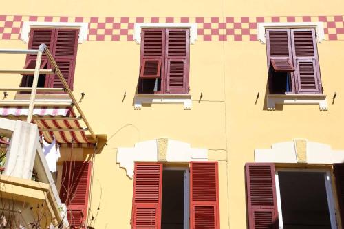 a yellow building with red shuttered windows on it at La Rosa Dei Venti in Monterosso al Mare