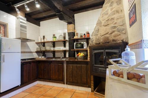 uma grande cozinha com uma grande parede de pedra em Natural&Mente El Tomillar em Pasarón