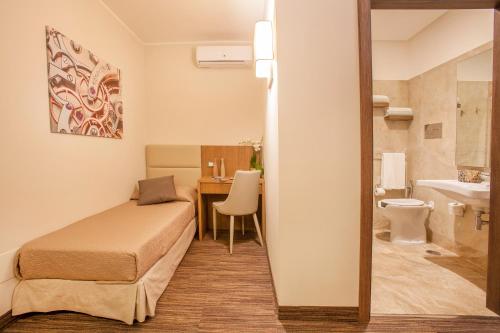 ナポリにあるB&B Dimora San Feliceのベッド1台とバスルームが備わる小さな客室です。