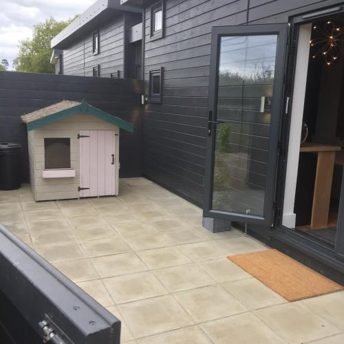 a patio with a dog house on the side of a house at Willow Court Farm Studio West & Petting Farm, 8 mins to Legoland & Windsor, 15 mins to Lapland UK in Windsor