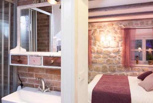 een slaapkamer met een bed, een wastafel en een spiegel bij Guesthouse Rustico in Dubrovnik