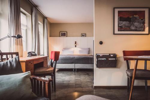 a hotel room with a bed and a desk at Henri Hotel Hamburg Downtown in Hamburg