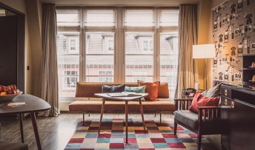 a living room filled with furniture and a window at Henri Hotel Hamburg Downtown in Hamburg