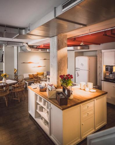 a large kitchen with a counter and a dining room at Henri Hotel Hamburg Downtown in Hamburg