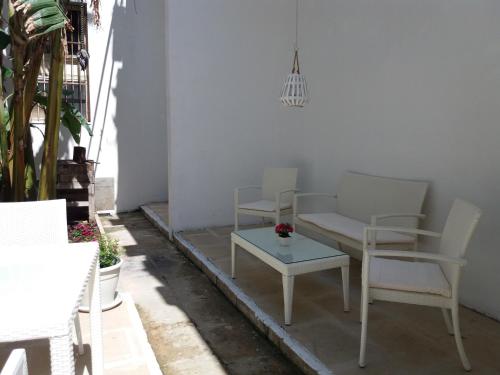 a patio with chairs and a couch and a table at Antico Palazzo Spinola in Gallipoli