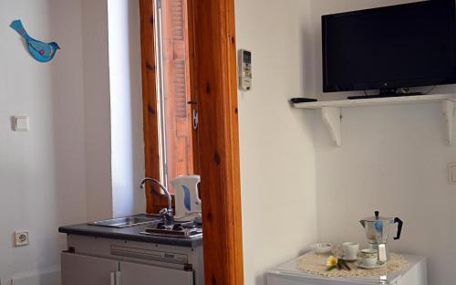 a kitchen with a sink and a television on a wall at Hera Studios in Chania