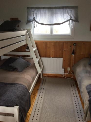 ein Schlafzimmer mit zwei Etagenbetten und einem Fenster in der Unterkunft Lillstugan in Älvkarleby