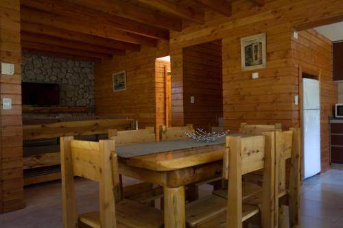 a wooden dining room with a table and chairs at Encanto del Rio in Villa La Angostura