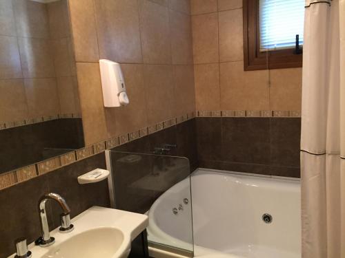 a bathroom with a sink and a bath tub at Encanto del Rio in Villa La Angostura