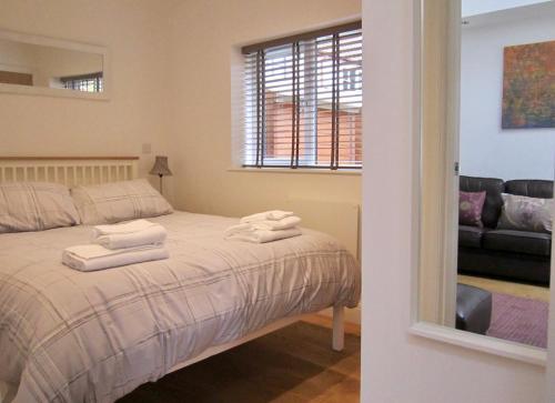 1 dormitorio con 1 cama con 2 toallas en Temeside Garden House en Ludlow