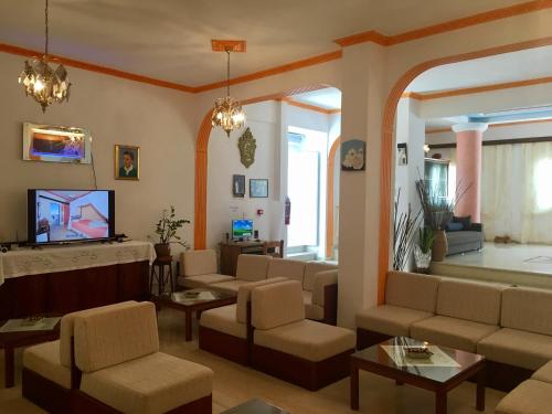 a living room with a couch and a tv at Hotel Lodos in Karterados