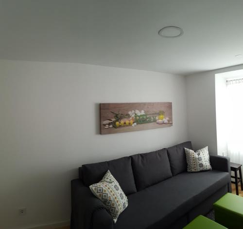 a living room with a couch and a painting on the wall at Stay In Alfama in Lisbon