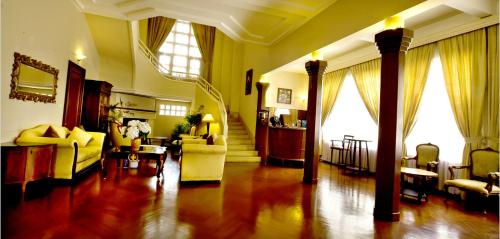 a large living room with yellow furniture and windows at Dalat Cadasa Resort in Da Lat