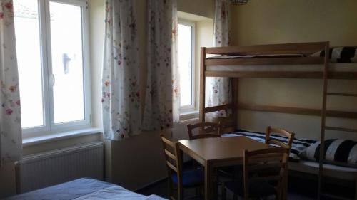 a bedroom with a table and a bunk bed at Pension Altwahnsdorf in Radebeul