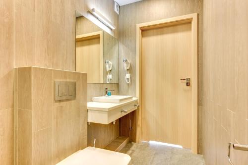 a bathroom with a toilet and a sink and a mirror at Baltic Sands in Hel