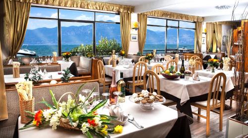 a restaurant with tables and chairs with a view of the ocean at Taki Village in Brenzone sul Garda