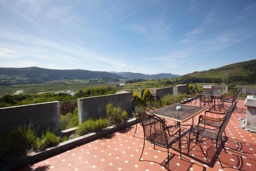 a patio with chairs and a table on a roof at Hotel Castillo de Arteaga in Gautegiz Arteaga