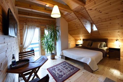 a bedroom with a bed in a wooden cabin at Žuvienės Pašiūrė in Rubikiai