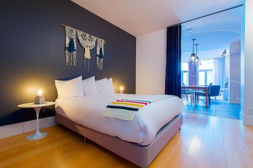 a bedroom with a large bed and a dining room at Les Lofts St-Joseph - Par Les Lofts Vieux-Québec in Quebec City