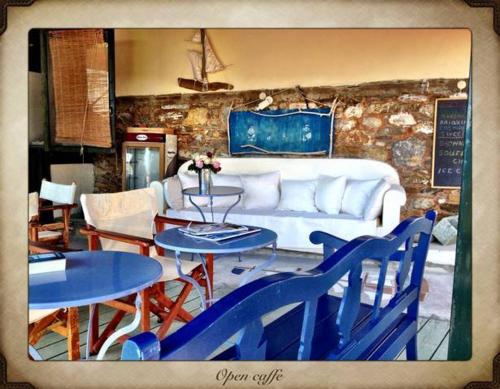 a living room with blue tables and a white couch at Aperanto Galazio in Skopelos Town