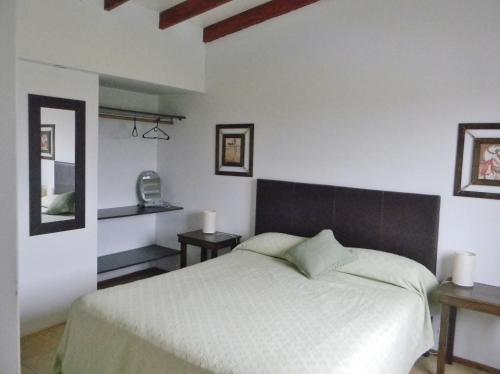 a bedroom with a large white bed and two tables at Complejo Colon Village in Colón
