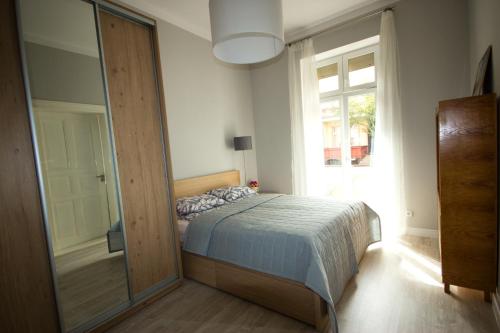 sypialnia z łóżkiem i dużym lustrem w obiekcie Apartament Paderewskiego 11 w Świnoujściu