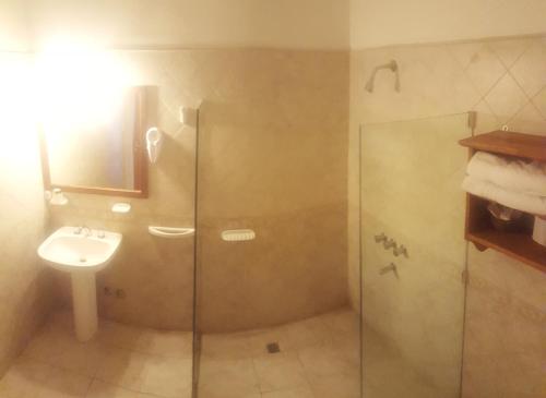 a bathroom with a glass shower and a sink at Montecassino in Capilla del Monte