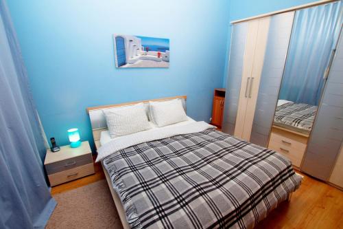 a blue bedroom with a bed and a mirror at Tverskaya Street Apartments in Moscow