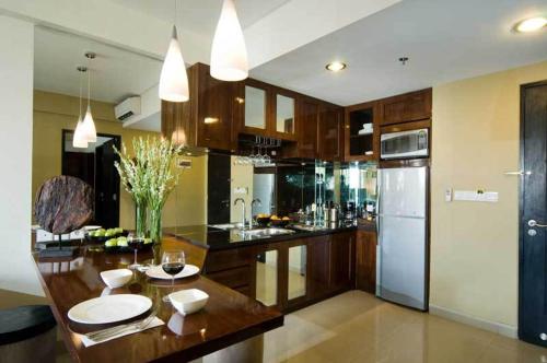 a kitchen with a table and a refrigerator at Kuta Luxury Residence in Kuta