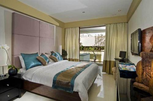 Un dormitorio con una cama grande y una ventana. en Kuta Luxury Residence, en Kuta
