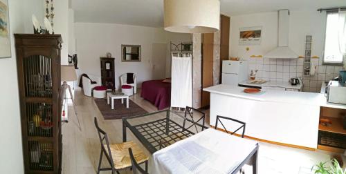 a kitchen and living room with a table and chairs at Les Petunias in Hugier