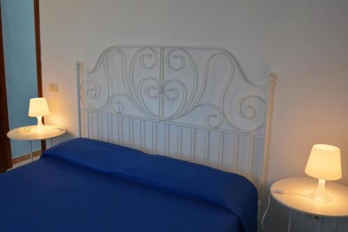 um quarto com uma cama azul e 2 candeeiros em Residence Mare Blu em Lampedusa
