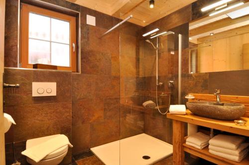 y baño con ducha acristalada y lavamanos. en Ferienhütten Lechtal Chalets, en Elbigenalp